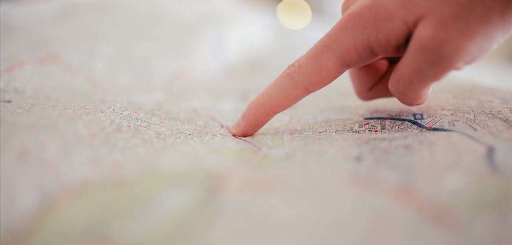 A hand points at a map